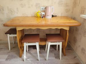 een houten tafel met twee stoelen en een blender erop bij Апартаменты Гоголя 46 in Karagandy