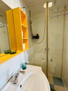 uma casa de banho com um lavatório e um chuveiro em Lev Florentin Apartments - Montefiore TLV em Tel Aviv