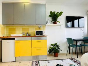uma cozinha com armários amarelos e uma mesa em Lev Florentin Apartments - Montefiore TLV em Tel Aviv