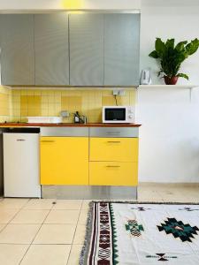 a kitchen with yellow cabinets and a white refrigerator at Lev Florentin Apartments - Montefiore TLV in Tel Aviv