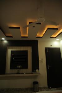 a room with a tv and a ceiling with lights at HOTEL BEST BUY in Kolkata