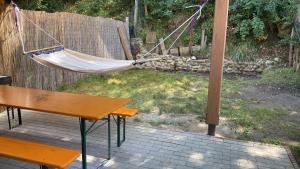 a hammock in a backyard with a table and a bench at SKH R - 1 Bedroom in Praid