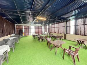a room with tables and chairs and green carpet at Hotel Mussoorie International in Mussoorie