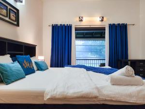 a bedroom with a large bed with blue curtains at Beach Villa Morjim in Morjim