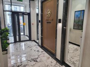 a lobby with a wooden door in a building at Толе Би 57 - ТРЦ Хан Шатыр in Astana