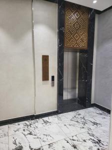 a lobby with a door and a wall with marble at Толе Би 57 - ТРЦ Хан Шатыр in Astana