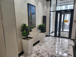 un couloir avec deux plantes en pot dans un bâtiment dans l'établissement Толе Би 57 - ТРЦ Хан Шатыр, à Astana