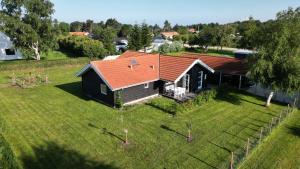 une vue aérienne sur une maison avec un toit rouge dans l'établissement Moderne sommerhus, 8 senge, 250 mtr til sandstrand, à Slagelse