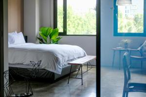 a bedroom with a bed and a table and a chair at Tomato TTT 番茄行旅 in Taipei