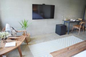 a living room with a couch and a tv on the wall at Tomato TTT 番茄行旅 in Taipei