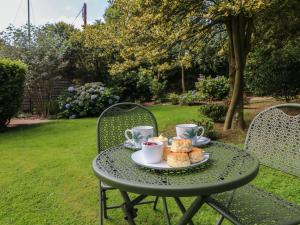 a table with a plate of pastries and cups of coffee at Jasmine in Barnstaple +11 photos