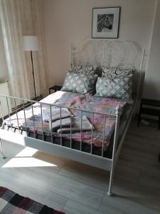 Una cama con marco de metal y almohadas. en Kuća Jovanka en Zaječar