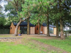 a wooden cabin with trees in front of it at Jasmine in Barnstaple