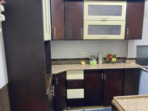 a kitchen with brown cabinets and a microwave at Assuit ultra modern apartment in Asyut