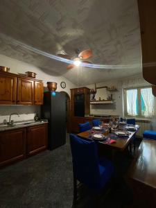 cocina con mesa con sillas azules y comedor en La Palma di Rafé en Génova