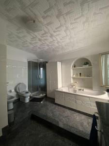 łazienka z 2 umywalkami, wanną i toaletą w obiekcie La Palma di Rafé w Genui