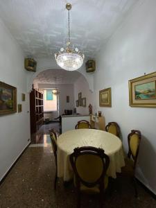 una sala da pranzo con tavolo, sedie e lampadario pendente di La Palma di Rafé a Genova