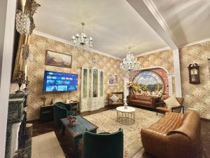 - un salon avec un canapé et une télévision dans l'établissement Boutique Hotel Alegria, à Tbilissi