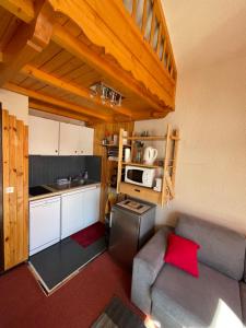 eine kleine Küche mit einem Sofa und einer Mikrowelle in der Unterkunft Appartement Plein Sud Cosy 6 personnes très bien équipé ,Vue splendide, Terrasse, Spacieux,Bien situé, Randonnées,Ski in Saint-Sorlin-dʼArves