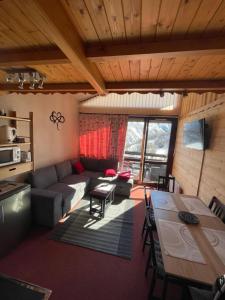 uma sala de estar com um sofá e uma mesa em Appartement Plein Sud Cosy 6 personnes très bien équipé ,Vue splendide, Terrasse, Spacieux,Bien situé, Randonnées,Ski em Saint-Sorlin-dʼArves