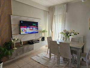 comedor con mesa y TV en la pared en House Gardenie B&B, en Crispiano