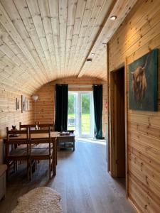 a dining room with a table and a large window at Dwell on the Moor in Holme upon Spalding Moor