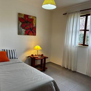 1 dormitorio con 1 cama y 1 mesa con lámpara en Casa Girasoles en Centenario