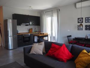 een woonkamer met een grijze bank met rode en gele kussens bij Bozen - voll ausgestattet, optimale Lage in Bolzano