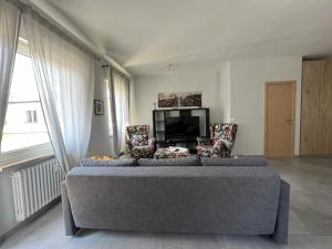 een woonkamer met een bank en een televisie bij Bozen - voll ausgestattet, optimale Lage in Bolzano