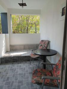 stół i 2 krzesła w pokoju z oknem w obiekcie Kuća Jovanka w mieście Zaječar