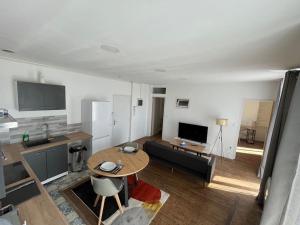 佩里格Charmant appartement avec balcon proche du centre.的配有桌子和沙发的厨房和客厅