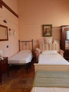 a bedroom with two beds and a chair in it at Il Casale dell'Acquabona in Montefano