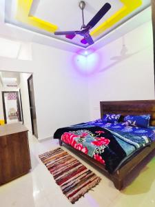 a bedroom with a bed and a ceiling fan at Deviksha Home Stay in Ujjain