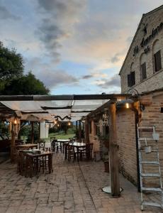 een patio met tafels en stoelen en een gebouw bij Il Casale dell'Acquabona in Montefano