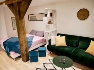 sala de estar con sofá verde y cama en Le nid douillet d'Honfleur, en Équemauville