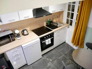 a small kitchen with a stove and a sink at Le nid douillet d'Honfleur in Équemauville