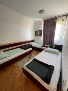 a bedroom with two beds and a window at Vila Grinka M in Zaječar