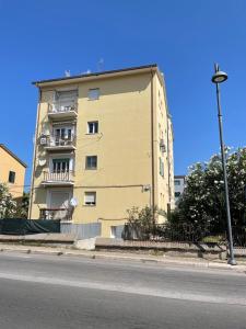 テルモリにあるAppartamento Coralloの通路脇の高い黄色の建物