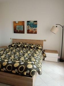 een slaapkamer met een bed en twee schilderijen aan de muur bij Domo Ilde in Oristano