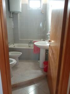 een badkamer met een wastafel, een toilet en een bad bij Domo Ilde in Oristano