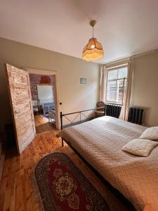 Un dormitorio con una cama grande y una ventana en Baznīcas ielas apartamenti, en Kuldīga
