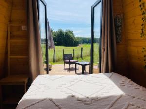 a bedroom with a bed and a view of a yard at Logement insolite : La Ruche Verte in Monts-sur-Guesnes