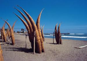 a group of wooden structures on a beach at MAGICPERU PET FRiENDLY in Trujillo