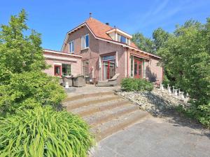 a brick house with stairs in front of it at Characteristic country house with wellness in Lijnden