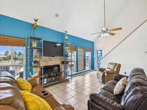 a living room with couches and a tv at Tiki Lagoon in Galveston