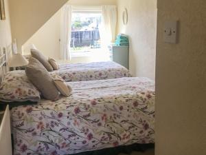 a bedroom with two beds and a window at Harbour Cottage in Millom