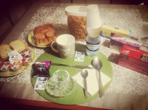 einen Tisch mit einem Teller Essen, einer Tasse und einem Löffel in der Unterkunft B&B Camera per uomini in Pescara