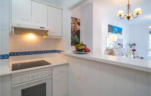 a kitchen with white cabinets and a stove top oven at Cozy Apartment In Fuengirola With Wifi in Fuengirola