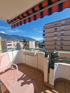 a balcony with a table and chairs and a view at Grand appartement 4-8 personnes in Montreux