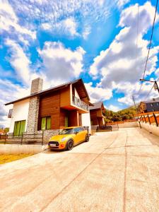 a yellow car parked in front of a house at Wonder Hill group in Bakuriani